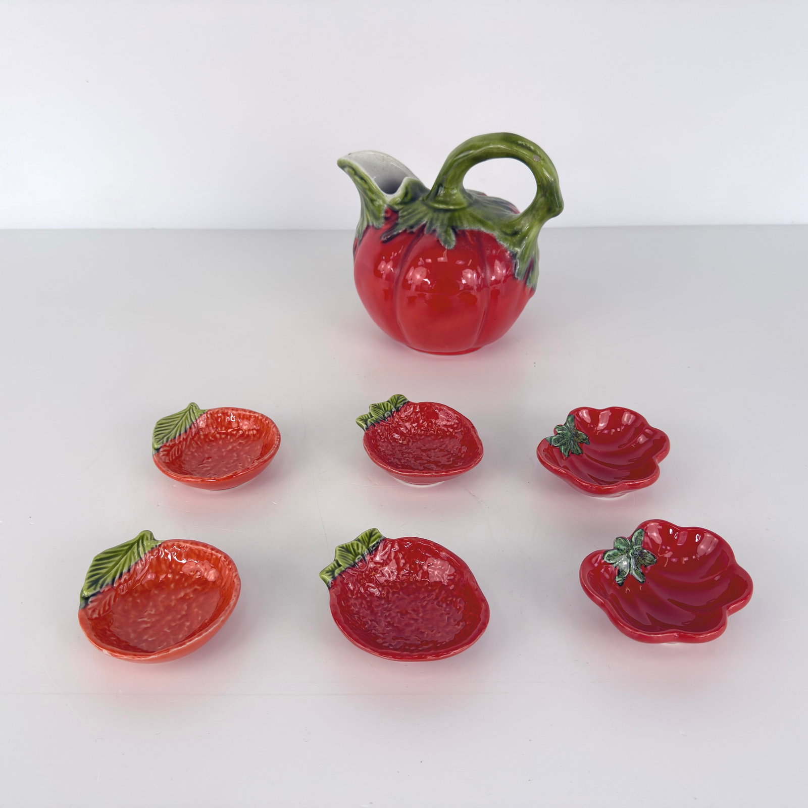 VINTAGE MAJOLICA CERAMIC SET: Dimensions: H 6.5” x W 8”. Set of 6 matching small bowls and a figural pitcher, hand painted. Dimensions: W 4” x D 3”.