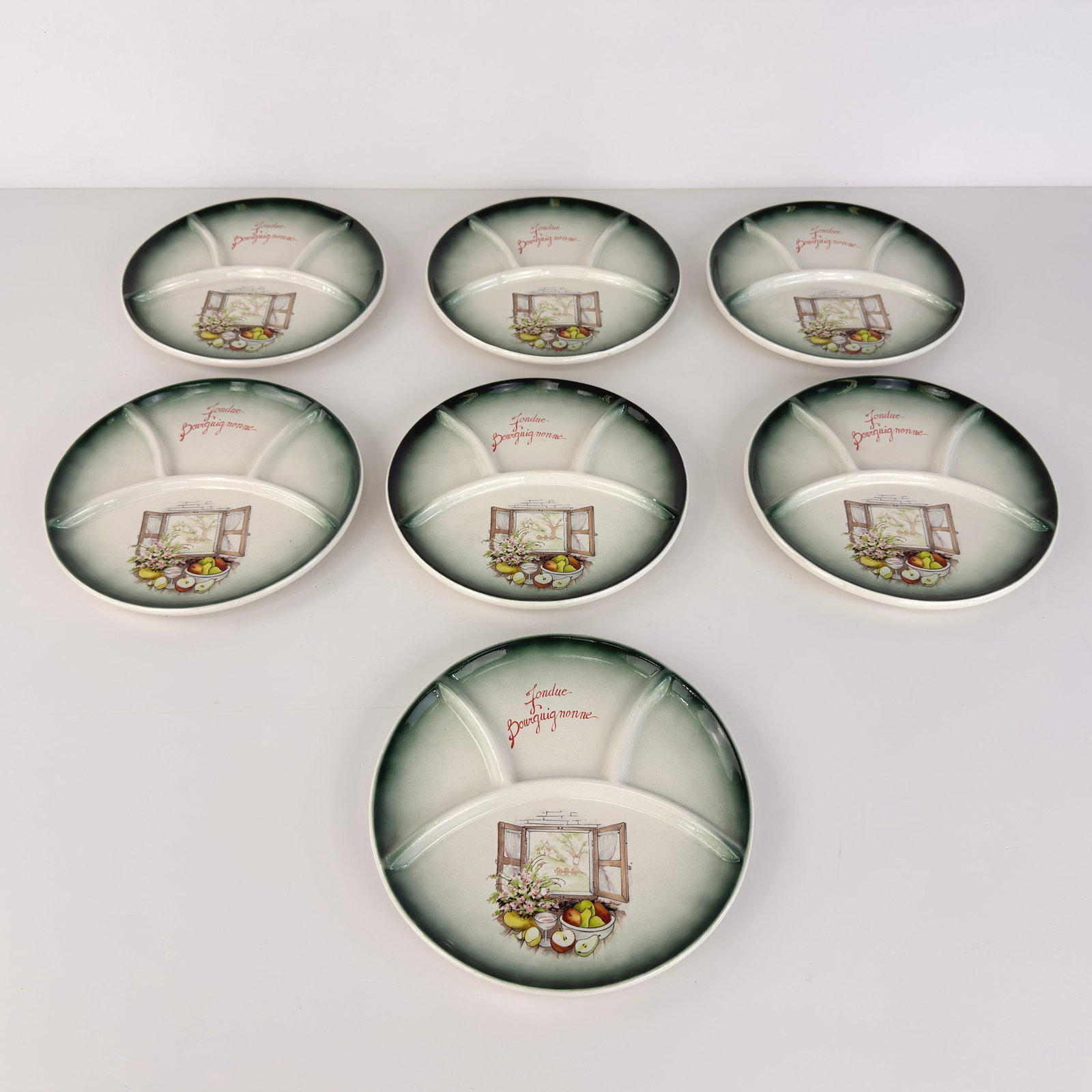 (7) CERAMIC FONDUE PLATES: Dimensions: W 10”. Set of 7 Vintage French porcelain fondue plates.