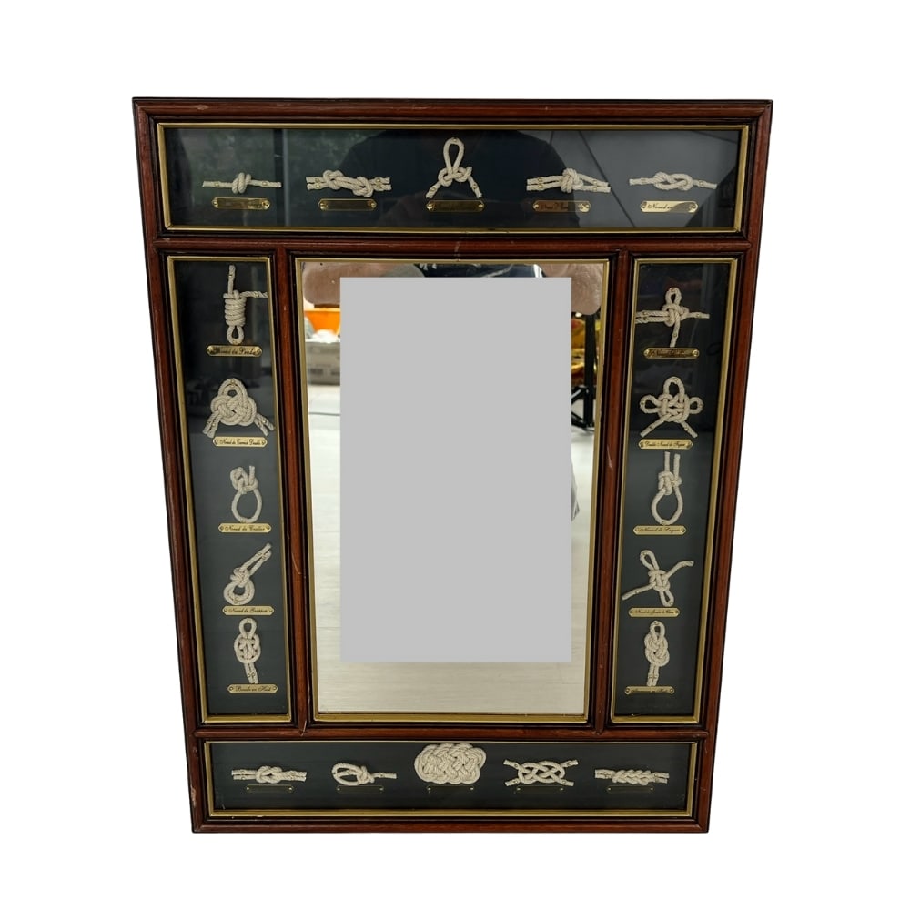 COASTAL NAUTICAL SHIP WALL MIRROR: Dimensions: H 23.5” x W 17.5”. Vintage wall mirror framed in nautical rope knots with names of all knots, engraved on brass plates.