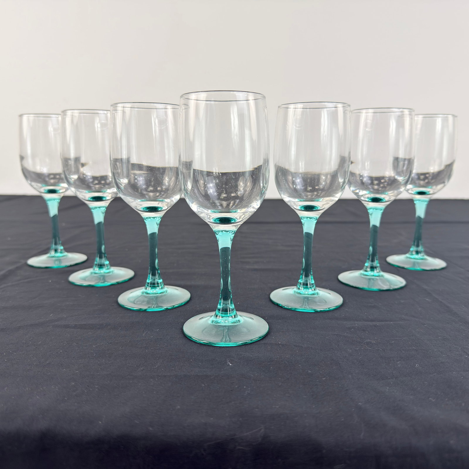 (7) LUMINARC WINE GLASSES: Dimensions: H 6.5” x W 2.3”. Set of 7 Luminarc France Aqua Stem wine glasses.