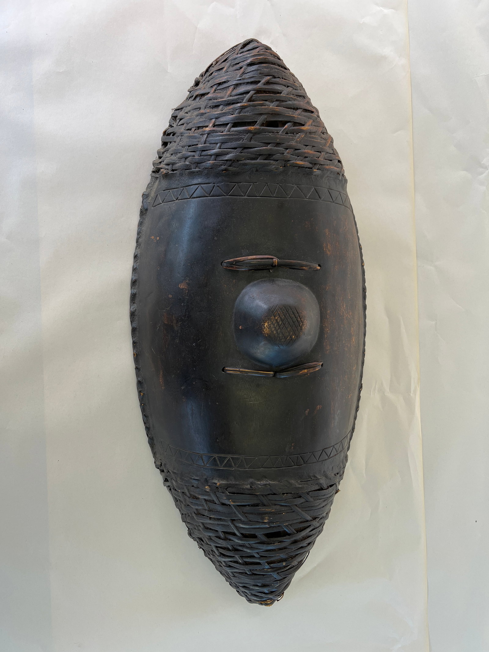 ANTIQUE HAND CARVED AFRICAN SHIELD: Dimensions: H 28.5” x W 13”. Antique hand carved and black painted wooden African shield.