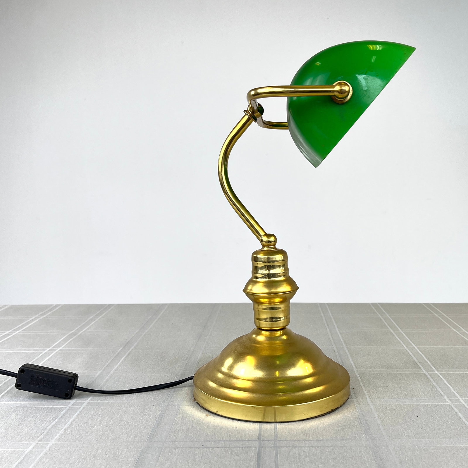 GREEN GLASS BANKER’S LAMP: Dimensions: H 15.7" x W 8". Banker’s lamp in gold metal and green colored glass shade.