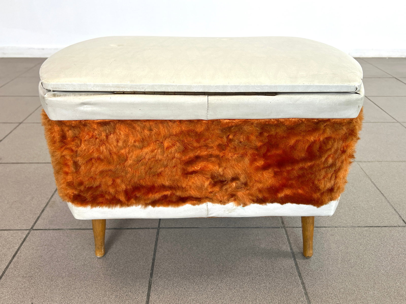 VINYL STORAGE OTTOMAN, 1960s: Dimensions: H 15.7” x W 22.5” x D 13.7”. Vinyl lift top storage ottoman with woollen band, from 1960s.