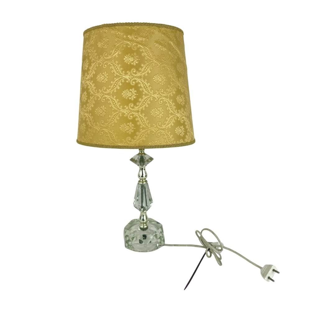 ART DECO CLEAR GLASS TABLE LAMP: Dimensions: H 13” x W 4.5”. French Art Deco clear glass table lamp with gold-patterned fabric lampshade.