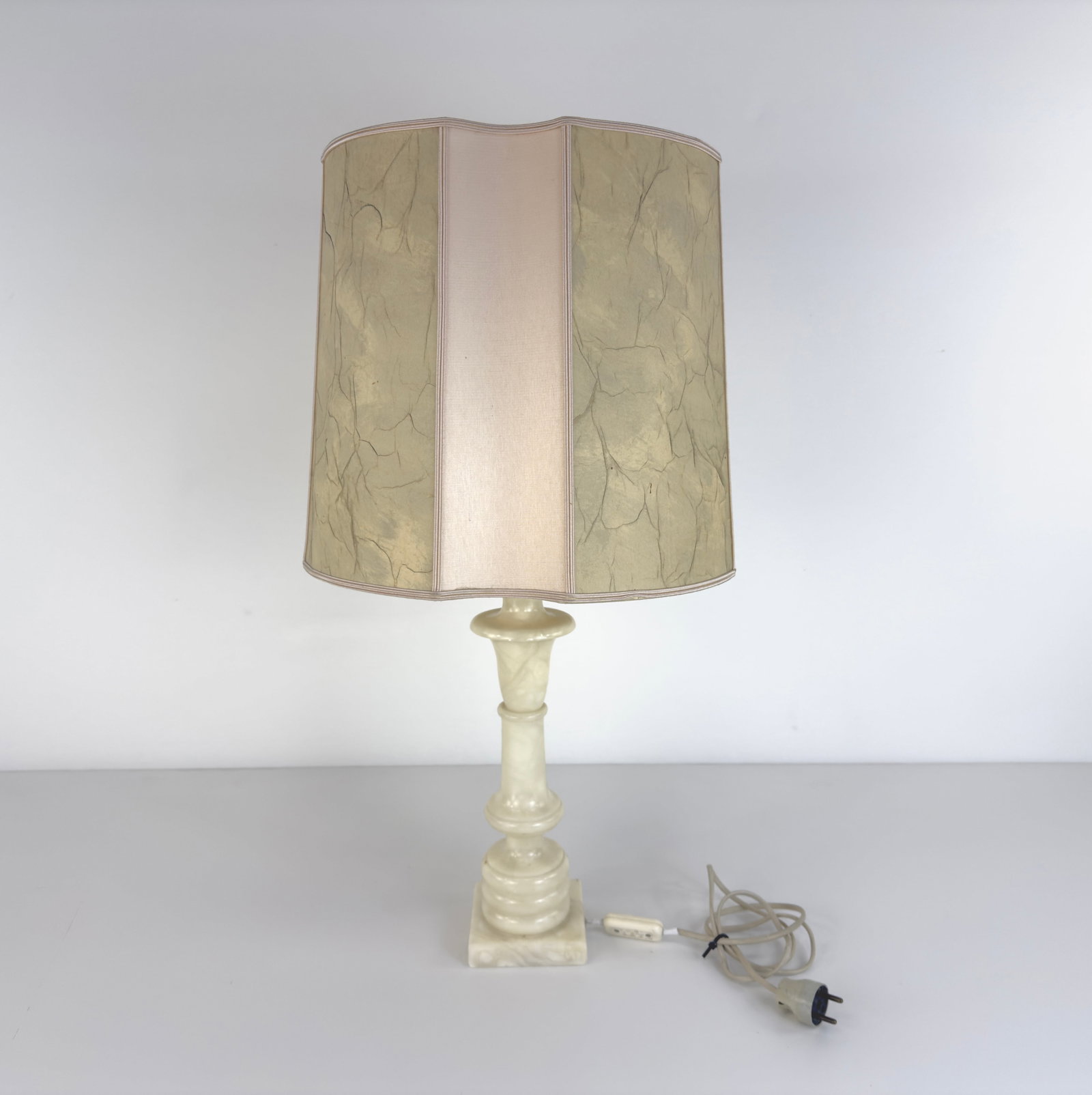 ALABASTER TABLE LAMP: Dimensions: H 17.7” x W 4.7”. French alabaster table lamp with light pink and beige lampshade.