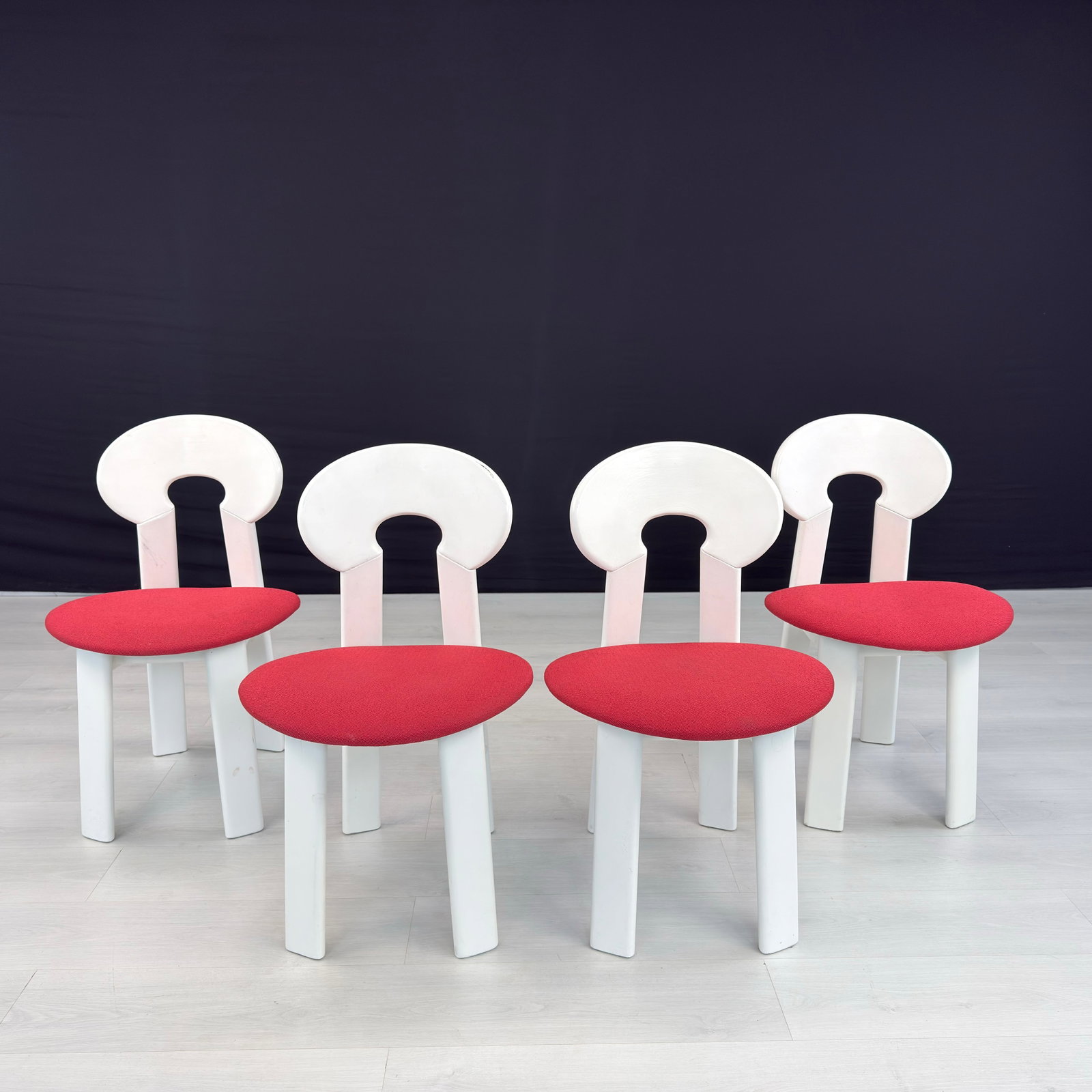 (4) BRUTALIST DINING CHAIRS MANNER OF CH990 EYELET CHAIR: Dimensions: H 31.5” x W 19.5” x D 19” x SH 18”. Set of 4 Vintage dining chairs manner of CH990 Eyelet Chair, painted in white with original red fabric seats.