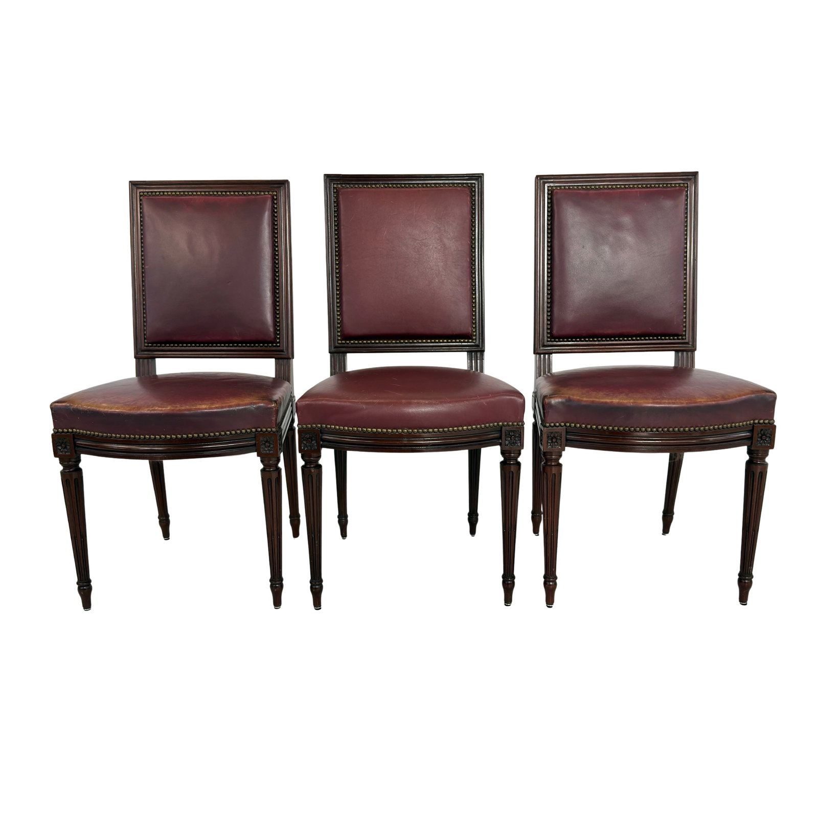 (3) LOUIS XVI STYLE DINING CHAIRS: Dimensions: H 37” x W 19” x D 20” x SH 19”. Set of 3 French Louis XVI style dining chairs in original dark red/brown leather with nail head trim detail. Two of the chairs are t