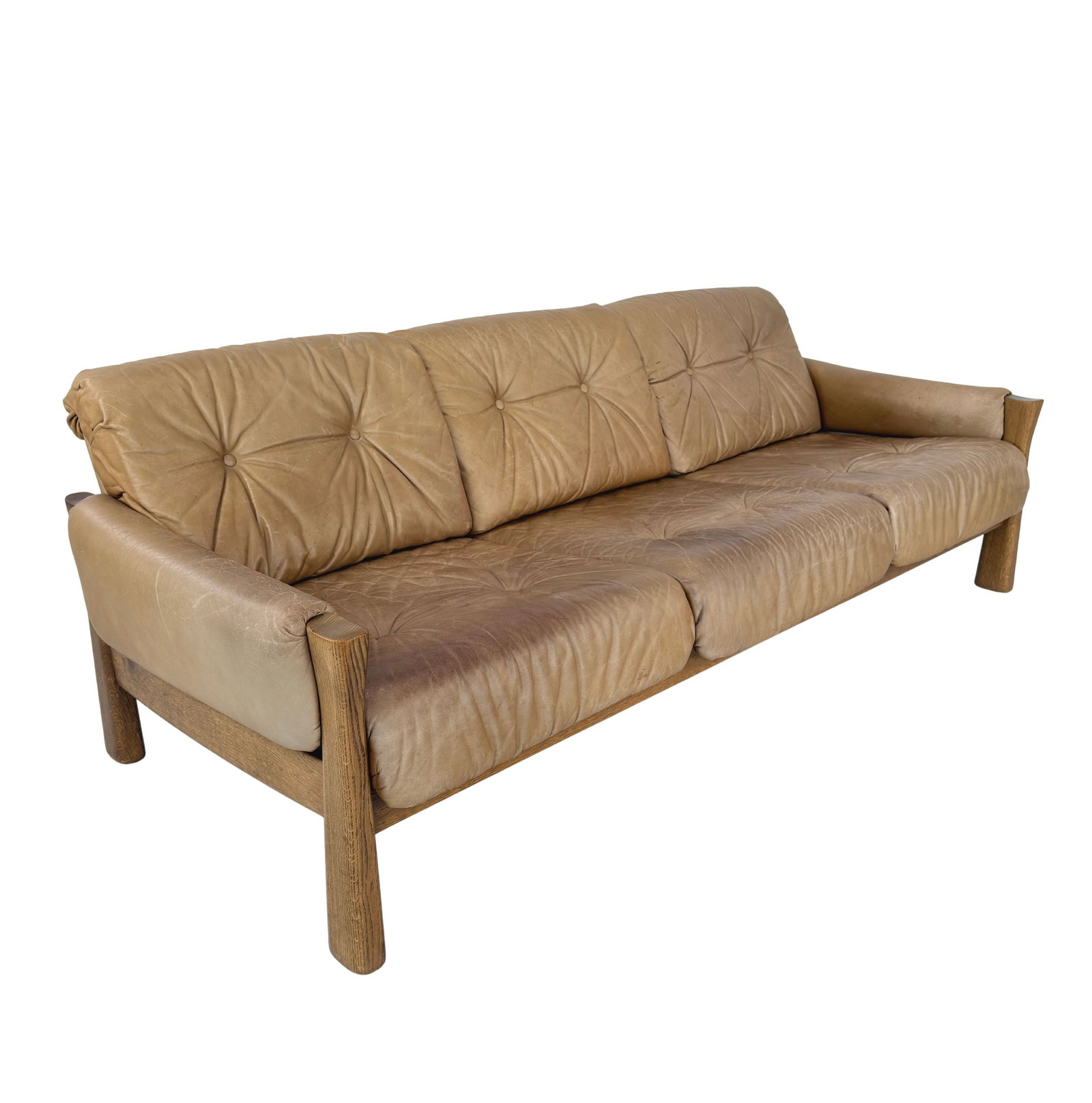 VINTAGE BRUTALIST LEATHER SOFA, 1970s: Dimensions: H 29.5” x W 80.7” x D 33". Vintage Brutalist SG Model light brown leather three-seater sofa with oak frame and loose padded cushions.