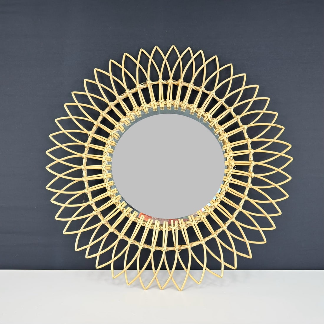 RATTAN SUNBURST MIRROR: Dimensions: W 29 ”. Vintage rattan sunburst wall mirror. Dimensions: (mirror) W 14.5”.