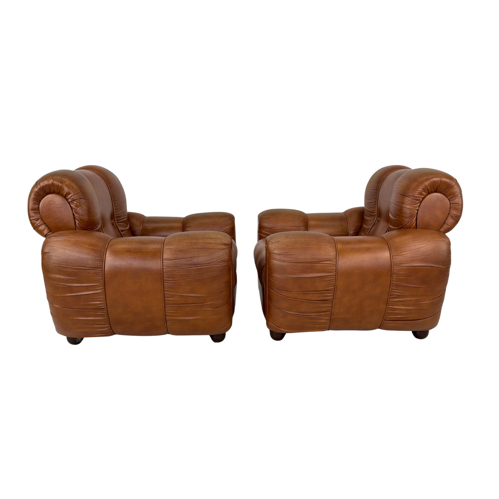 ITALIAN FAUX LEATHER ARMCHAIRS, A PAIR: Dimensions: H 33” x W 37.5” x D 36” x SH 16.5”. Pair of Vintage Italian Space Age cognac faux leather lounge chairs with loose padded cushions.