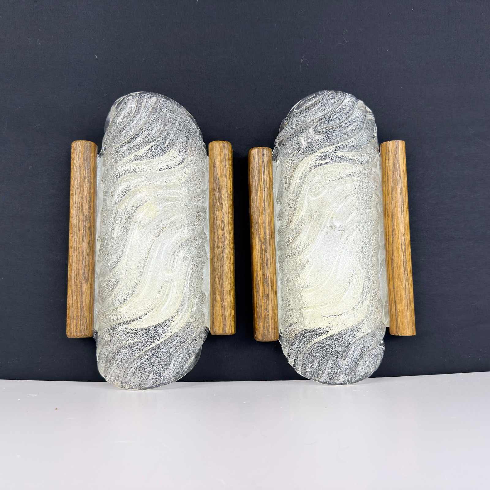 SPACE AGE WALL SCONCES FROM FISCHER LEUCHTEN, A PAIR: Dimensions: H 11.3” x W 6.3”. Pair of German Space Age wall sconces from Fischer Leuchten with ice glass shades with wooden side panels.
