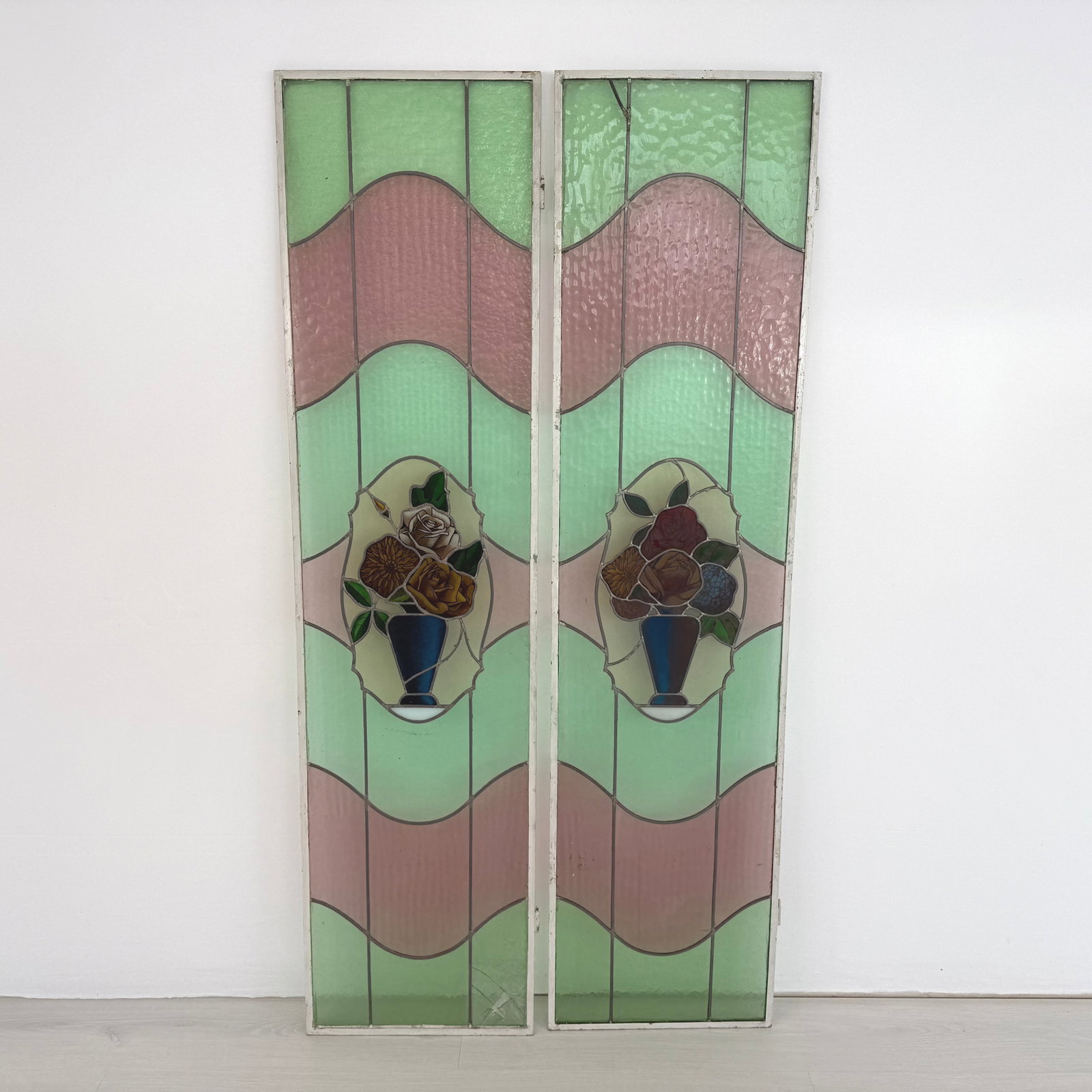 ANTIQUE STAINED GLASS PANELS, A PAIR: Dimensions: H 64” x W 16”. Pair of Antique stained glass window panels with rose motifs. Dimensions are for 1 pc.