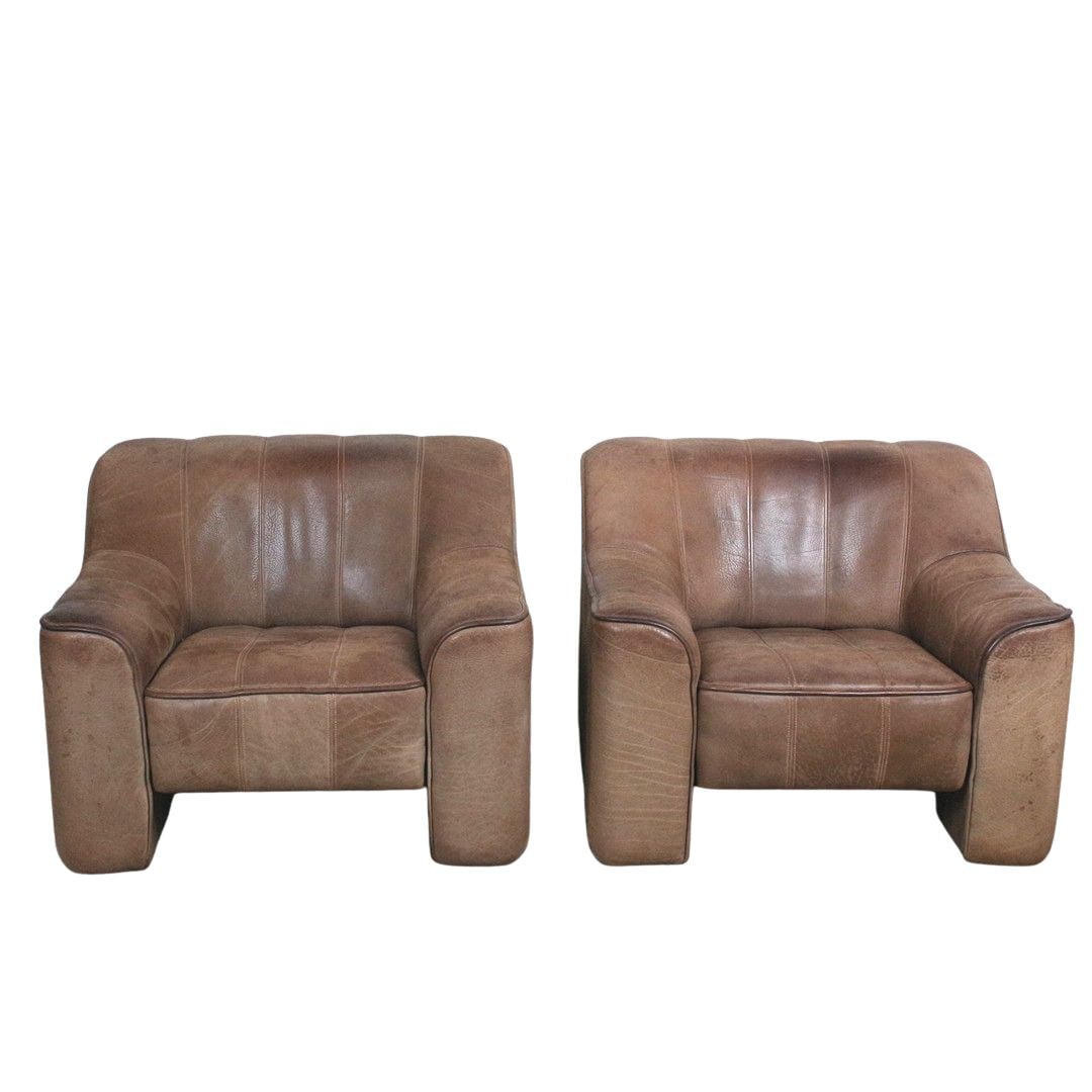 DE SEDE DS 44 LOUNGE CHAIRS, A PAIR: Dimensions: H 27.5” x W 34.8” x D 36” x SH 15.7”. Pair of Swiss brown Buffalo leather lounge chairs model DS 44 from De Sede, 1970s.