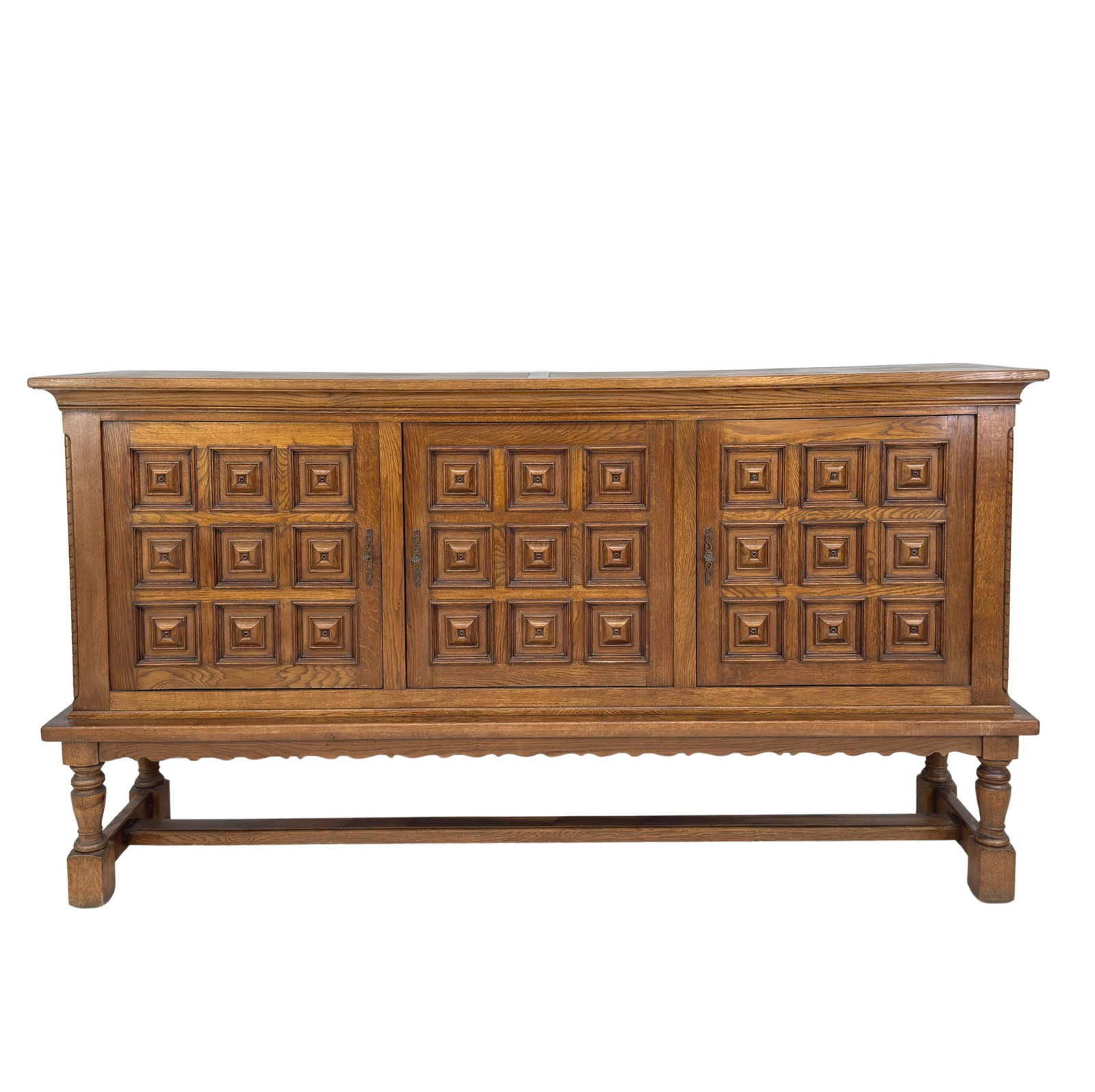 BRUTALIST SIDEBOARD MANNER OF KJAERNULF: Dimensions: H 55.5" x W 101" x D 21.5". Vintage Spanish carved oak sideboard with 3 cupboards with shelves inside, 3 keys included.