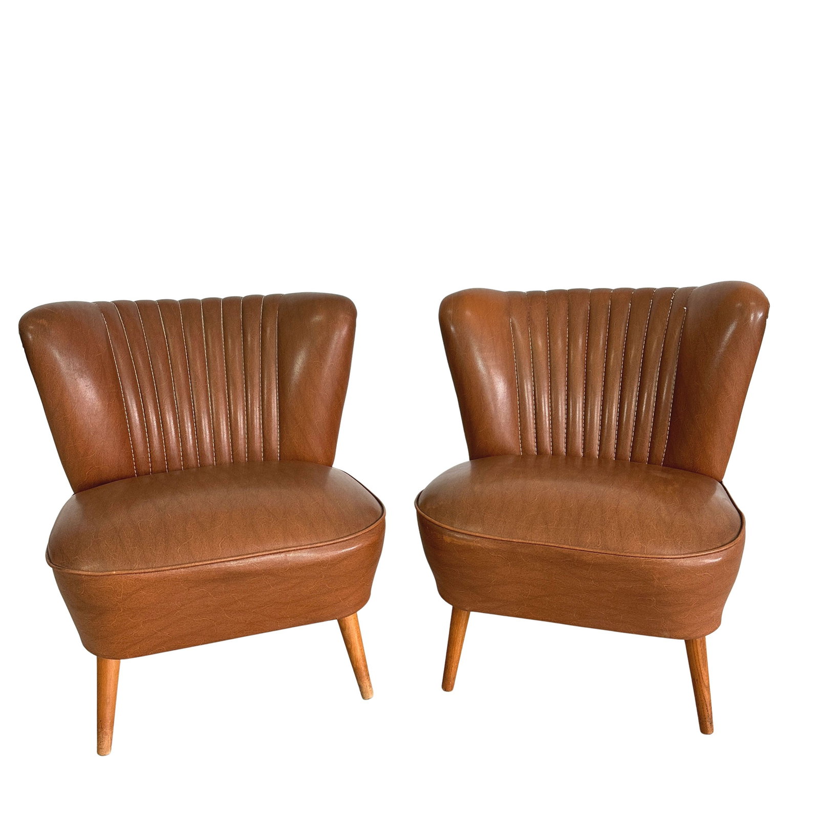 VINTAGE GERMAN COCKTAIL CHAIRS, A PAIR: Dimensions: H 25.5” x W 21” x D 22” x SH 16.5”. Pair of Vintage Cocktail chairs in brown faux leather with tapered legs.