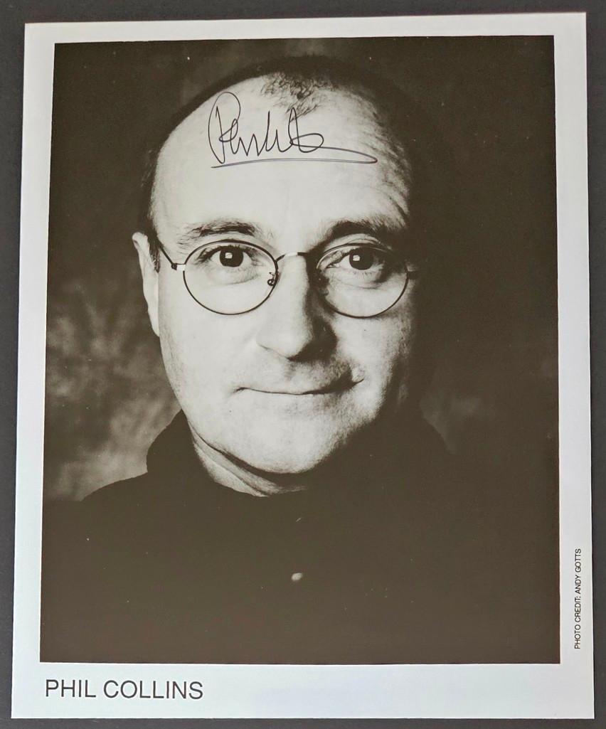 Genesis: Phil Collins Signed 8" x 10" Photo (Third Party Guaranteed): Black and white 8” x 10” promo photo signed in black ink by Phil Collins. In fine condition. Provenance Eaton & Brennan Auctions guarantees this lot to pass Third-Party Authentic