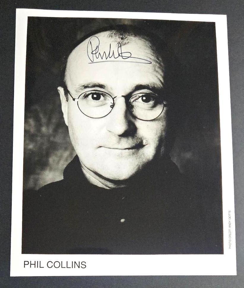 Genesis: Phil Collins In-Person Signed Photo (Third Party Guaranteed): Black and white 8" x 10" promo photo signed in black felt tip marker by Phil Collins. In fine condition. Obtained in-person. Provenance Eaton & Brennan Auctions guarantees this lot to pass Third-