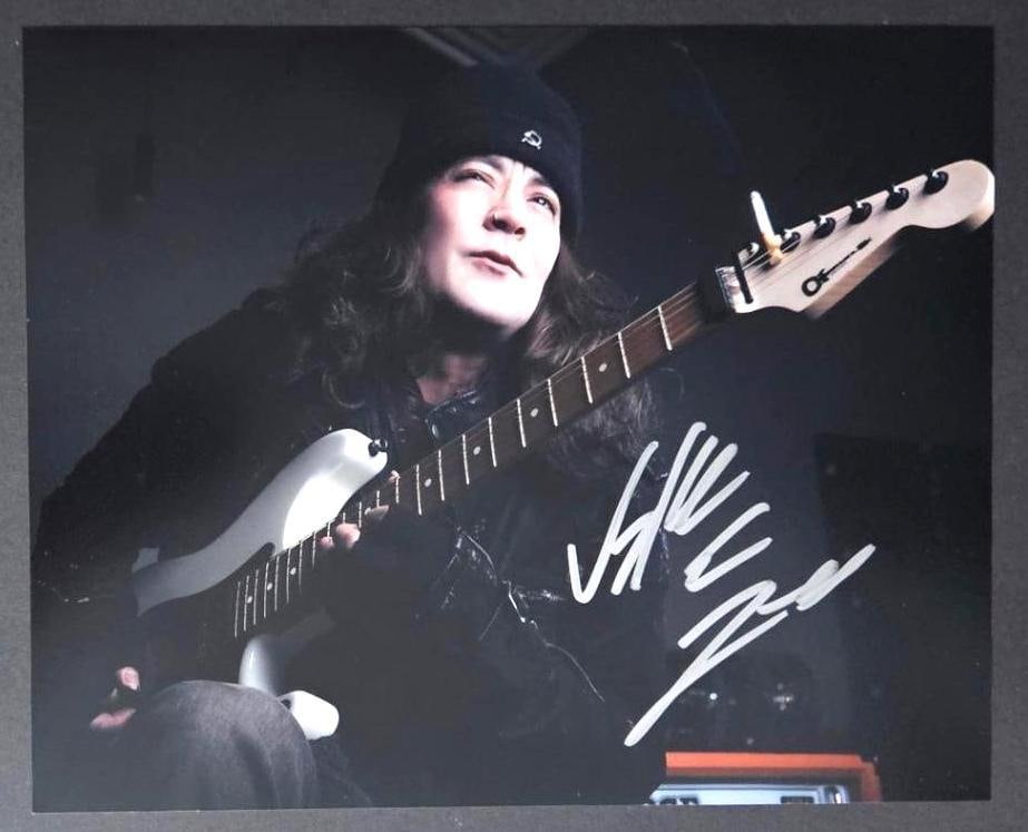 Jake E. Lee In-Person Signed Photo (Third Party Guaranteed): Color 8” x 10” photo of guitarist Jake E. Lee, signed in white paint pen by Jake E. Lee. In fine condition. Obtained in-person. Jake E. Lee is best known for his tenure as the lead gu