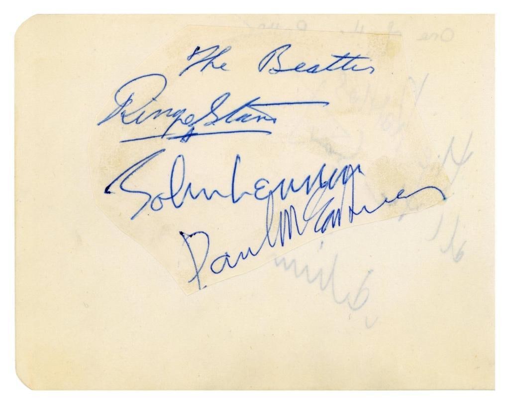 The Beatles Group In-Person Signed Autograph Book Page (3 Sigs) (Tracks COA): Autograph book page featuring an irregularly cut piece of paper affixed to it, signed in blue ink by John Lennon, Paul McCartney, and Ringo Starr, who has also written "The Beatles" above his name. Th