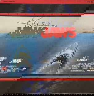 Jaws: John Williams Signed "Jaws" Laserdisc (Third Party Guaranteed): Signed laserdisc cover for the film "Jaws," autographed in blue felt tip marker by composer John Williams. The cover measures approximately 12" x 12". No disc included. In fine condition with minor ed
