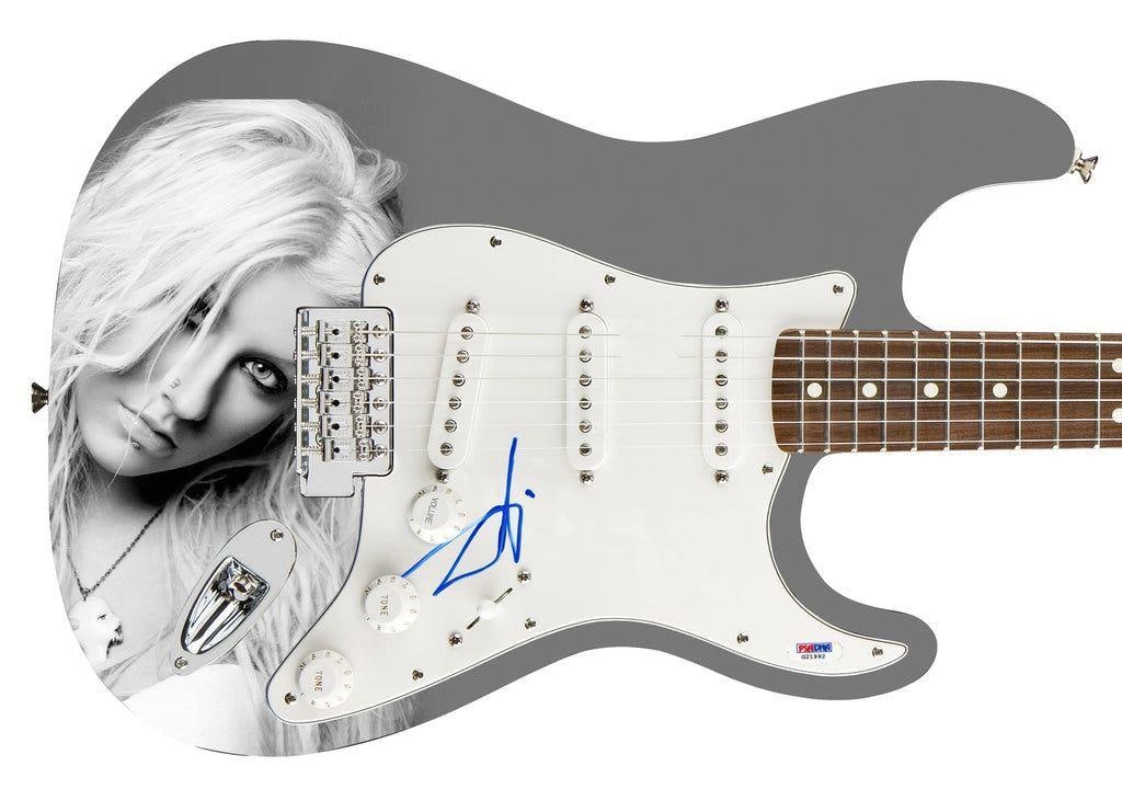 Christina Aguilera Signed Stratocaster-Style Guitar (PSA DNA Authentication): Christina Aguilera custom graphics stratocaster-style guitar signed on the pickguard in blue felt tip marker. Measuring approximately 41" x 17" x 3" and in fine condition. Authenticated by PSA DN
