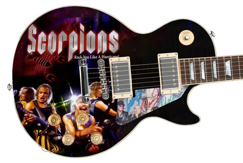 Scorpions Graphics Les Paul-Style Guitar w/ Custom-Made Group Signed Pickguard (3 Sigs) (REAL Auth.): Scorpions graphics Les Paul-style guitar signed on the custom-made pickguard in blue and red felt tip marker by Scorpions bandmembers Rudolph Schenker, Klaus Meine, and Matthias Jabs. Measuring 41R