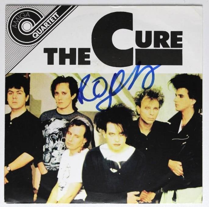 The Cure: Robert Smith Signed 45 Record (Beckett/BAS Authentication): “The Cure” 45 signed on the cover in blue felt tip marker by The Cure frontman Robert Smith. Measuring approximately 7” x 7” and in fine condition, obtained in-person. Record&#