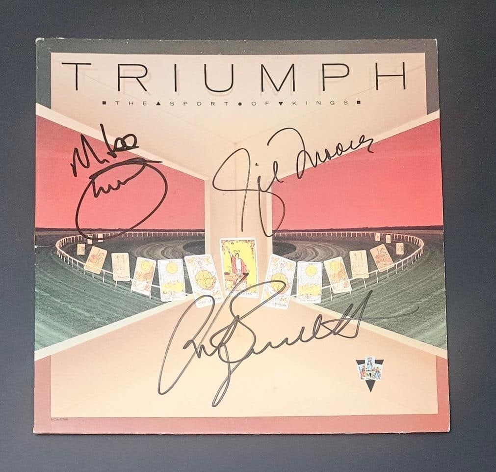 Triumph Group Signed “The Sport of Kings” Album (3 Sigs) (Third Party Guaranteed): “The Sport of Kings” album signed on the cover in black felt tip marker by Triumph band members Gil Moore, Rik Emmett, and Mike Levine. Measuring approximately 12” x 12” and in