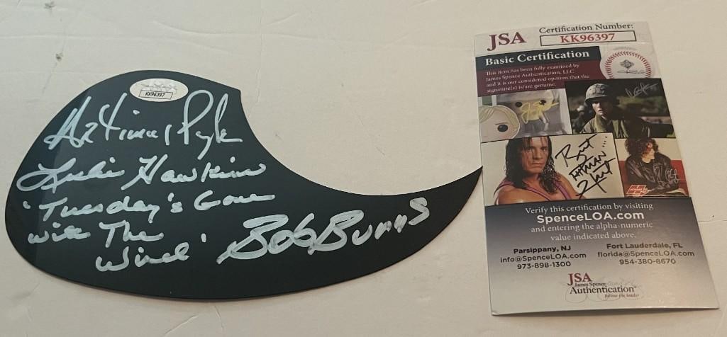 Lynyrd Skynyrd Group Signed Acoustic Pick Guard (3 Sigs) (JSA Authentication): Black 7" x 4" acoustic pick guard signed in silver felt tip marker by Lynyrd Skynyrd band members Artimus Pyle, Bob Burns, and Leslie Hawkins. Between Burns and Hawkins signatures's the song name