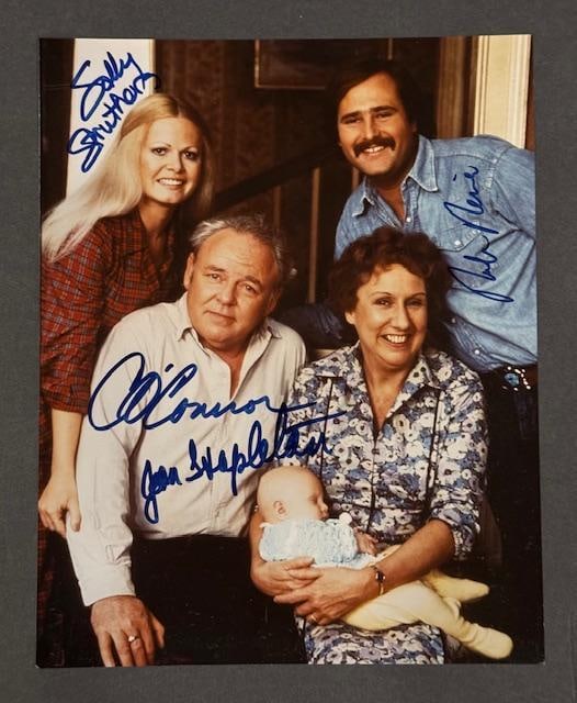 "All in the Family Cast" Signed 10" x 8" Photo (4 Sigs) (JSA Authentication): Color 10" x 8" photo of the cast of the television show "All in the Family" signed in blue felt tip marker by cast members Carroll O'Connor, Jean Stapleton, Sally Struthers, and Rob Reiner. In fine