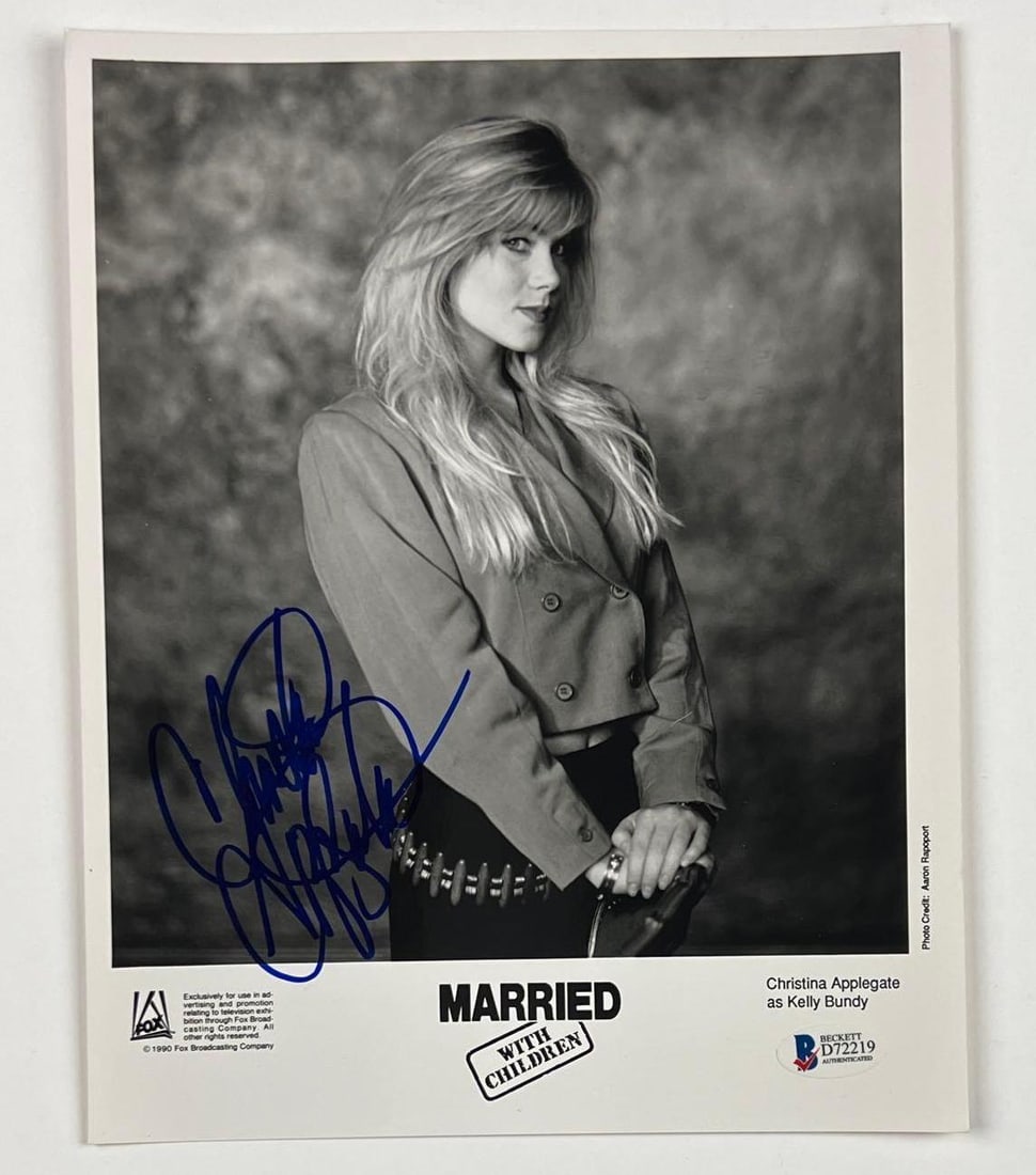 Christina Applegate Signed 10" x 8" "Married With Children" Promo Photo (Beckett/BAS): Black-and-white 10" x 8" original promotional photo for the television show "Married With Children" signed in blue felt tip marker by actress Christina Applegate. In fine condition. Obtained
