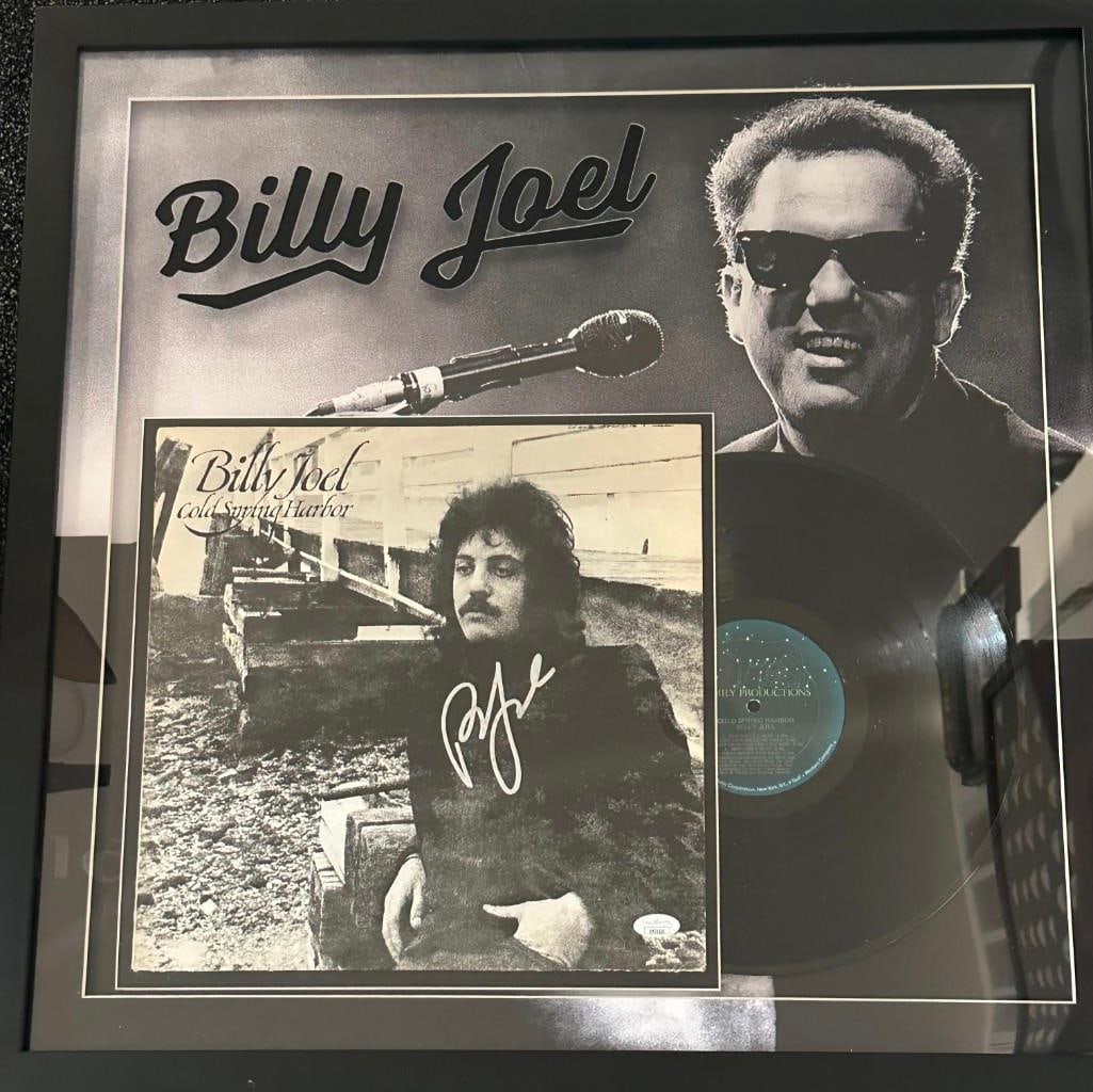 Billy Joel Signed "Cold Spring Harbor" Album Inside 26" x 26" Framed Display (JSA): "Cold Spring Harbor" album signed in silver felt tip marker by musician Billy Joel. Signed album measures 12" x 12" and in fine condition. Both record and album are displayed with an image of Joel as