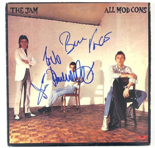 The Jam Group Signed "All Mod Cons" Album (3 Sigs) (JSA): "All Mod Cons" album signed in blue felt tip marker by The Jam band members Bruce Foxton, Rick Buckler, and Paul Weller. Measuring approximately 12" x 12" and in very good condition, with some signs o