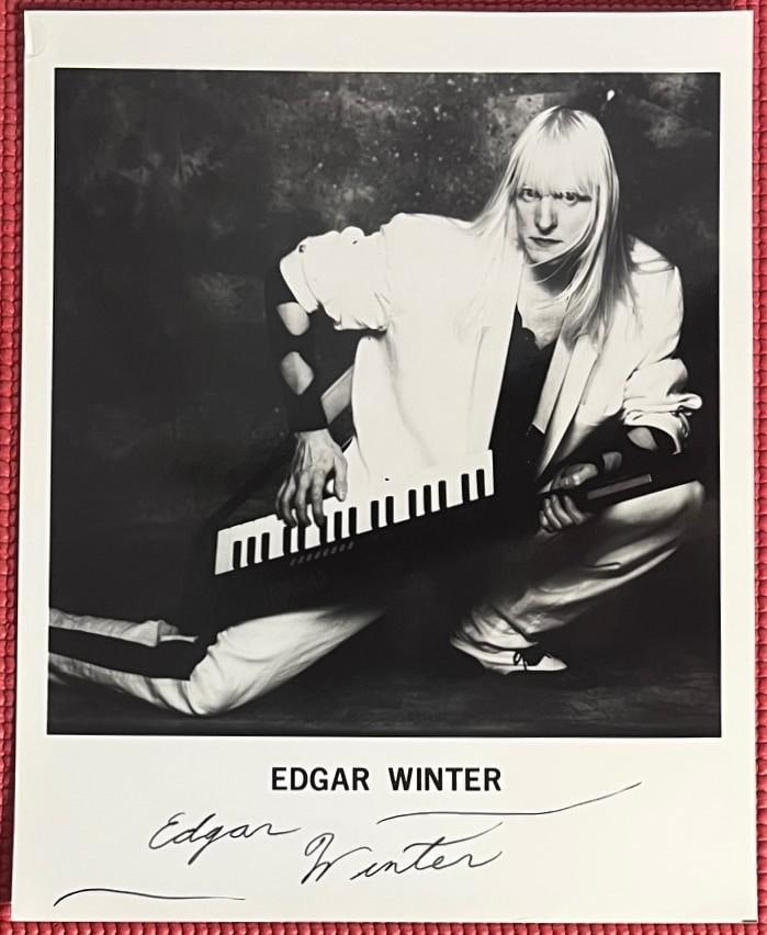 Edgar Winter Signed 10" x 8" Photo (PSA DNA Authentication): Black-and-white 10" x 8" photo signed in black felt tip marker by musician Edgar Winter. In fine condition. Authenticated by PSA DNA, with their official hologram affixed to the back lower right