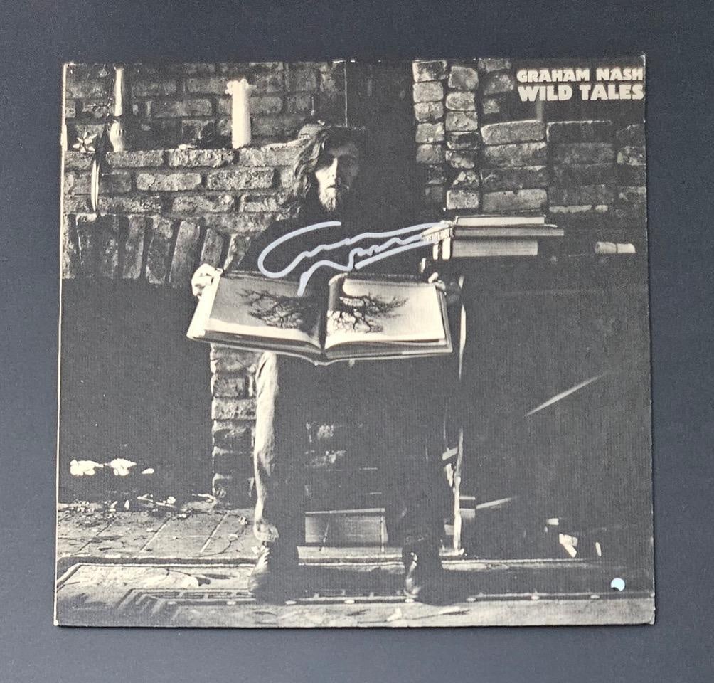 Graham Nash Signed "Wild Tales" Album (Third Party Guaranteed): "Wild Tales" album signed on the cover in silver felt tip marker by musician Graham Nash. Measuring approximately 12" x 12" and in fine condition. Record is included. Obtained