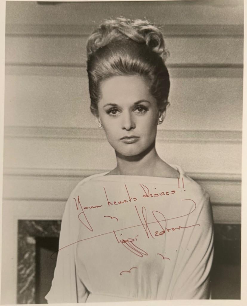 Alfred Hitchcock: Tippi Hedren "Marnie" Signed 10x8 Photo (PSA): Black-and-white 10" x 8" photo of character Marnie Edgar from the film "Marnie" signed in red ballpoint pen by actress Tippi Hedren, who inscribed the message "Your hearts desires!!" before her