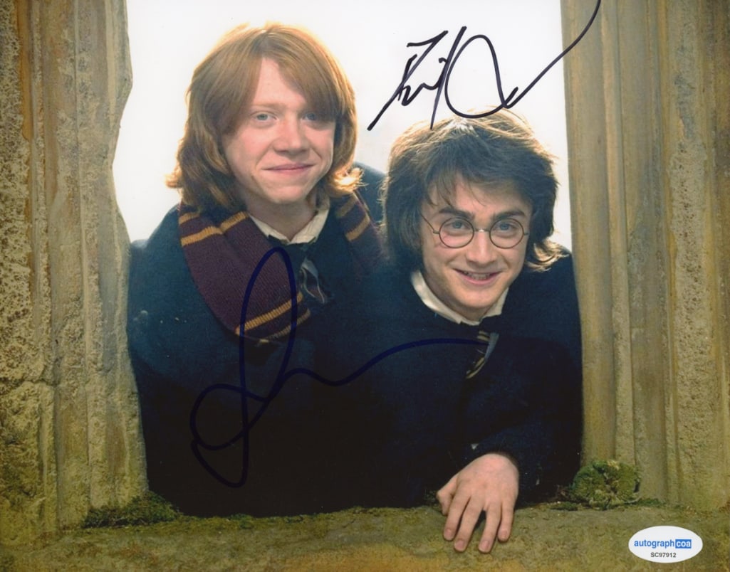 Harry Potter: Daniel Radcliffe & Rupert Grint Signed 8" x 10" Photo (2 Sigs) (ACOA Authentication): Color 8" x 10" photo of characters Harry Potter and Ron Weasley from the "Harry Potter" film franchise signed in blue and black felt tip markers by actors Daniel Radcliffe and Rupert Grint. In fine