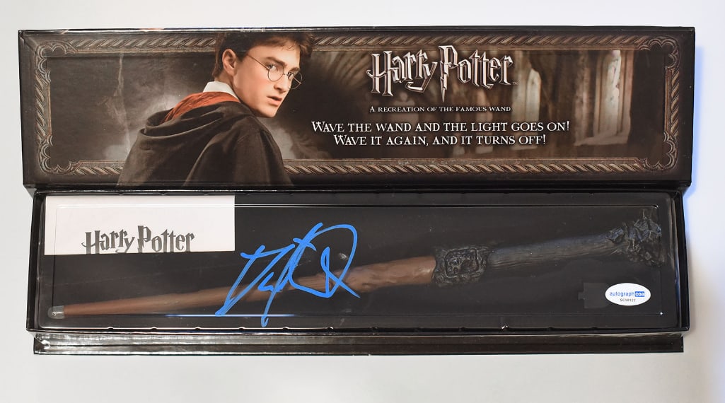 Harry Potter: Daniel Radcliffe Signed Noble Collection 14" Illuminating Wand (ACOA Authentication): "Harry Potter" Noble Collection 14" illuminating wand signed on the flat plastic covering in blue paint marker by actor Daniel Radcliffe. In fine condition. Obtained in-person. Accompanied by an ACOA