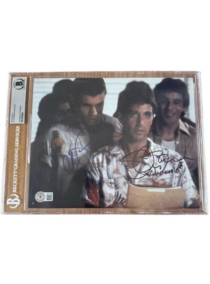 Scarface: Al Pacino & Steven Bauer Signed Slabbed 8" x 10" Photo (2 Sigs) (Beckett/BAS): Color slabbed 8" x 10" photo of characters Tony Montana and Manolo Ribera from the film "Scarface" signed in black and blue felt tip markers by actors Al Pacino and Steven Bauer. Bauer inscribed his
