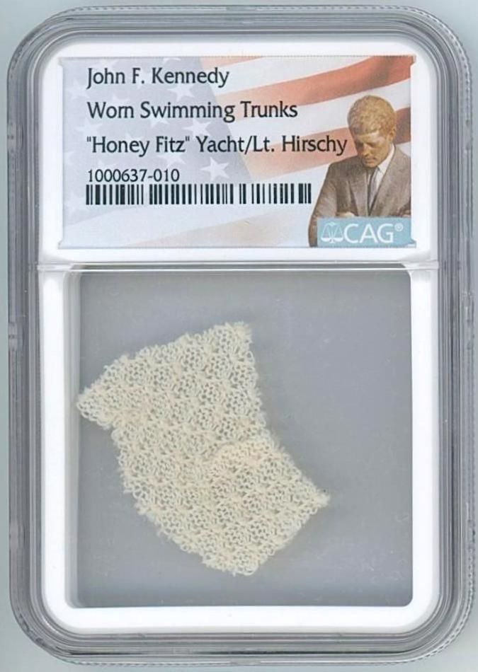 John F. Kennedy Swatch from Personally Worn Swim Trunks (CAG Encapsulated): A 1.5" x .75" swatch cut from a pair of swimming trunks personally worn by President John F. Kennedy. Encapsulated by CAG to an overall size of 2.375'' x 3.375''. Originally gifted to Lt. Henry Hirsch