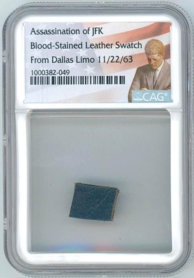 John F. Kennedy Blood-Stained Leather Swatch from Dallas Limo (CAG Encapsulated): Swatch of blood-stained blue leather upholstery, .5" x .5," removed from President John F. Kennedy's limousine following his assassination. Encapsulated by CAG to an overall size of 2.375" x 3.375". A