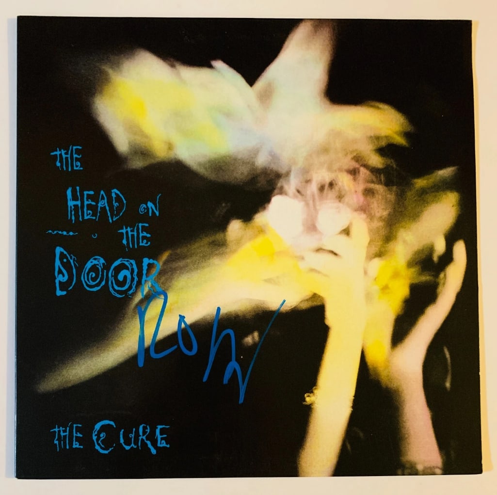 The Cure: Robert Smith Signed "The Head on the Door" Album (Beckett/BAS Authentication): "The Head on the Door" album signed on the cover in blue paint pen by The Cure front man Robert Smith. Measuring approximately 12" x 12" and in fine condition. Obtained in-person. Record is not includ