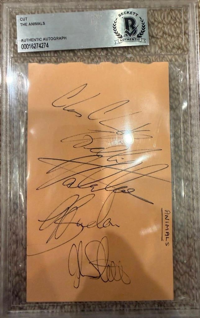 The Animals Group Signed Slabbed Cut (4 Sigs) (Beckett/BAS Authentication): Manilla paper slabbed cut signed in black ballpoint pen by The Animals band members Eric Burdon, John Steel, Chas Chandler, and Hilton Valentine. Read horizontally on the top right edge is the band na
