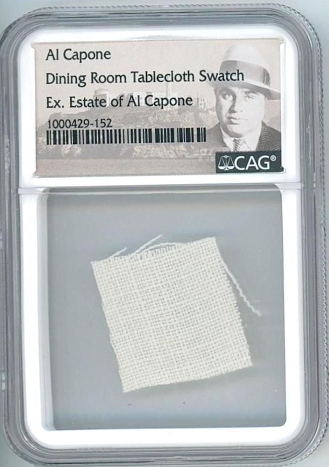 Al Capone Personally Owned Tablecloth Swatch (CAG Encapsulated): Swatch, approximately 1" x 1," taken from a dining tablecloth personally owned by Al Capone, sourced from the estate of his granddaughter, Barbara Mae Capone. Encapsulated by CAG to a size of 2.375"
