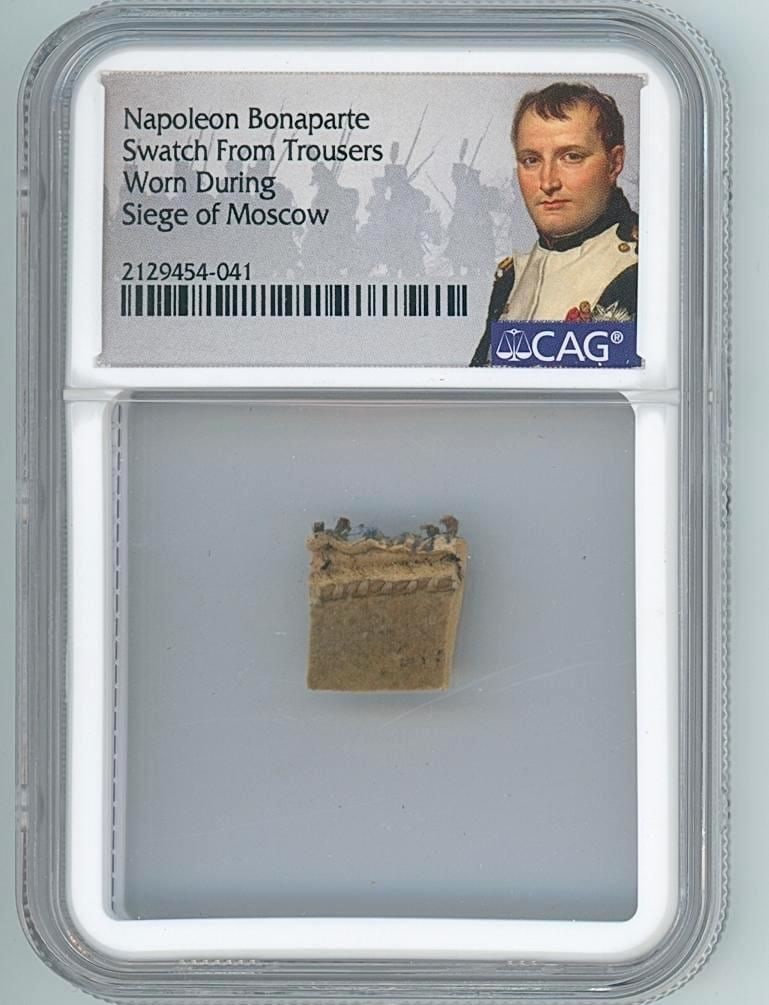 Napoleon Bonaparte Trousers Swatch from 1812 Russian Campaign (CAG Encapsulated): Napoleon Bonaparte pants fabric fragment from the 1812 Russian campaign, attributed to trousers discarded during the retreat from Moscow. The small piece of brown leather, measuring approximately .5"