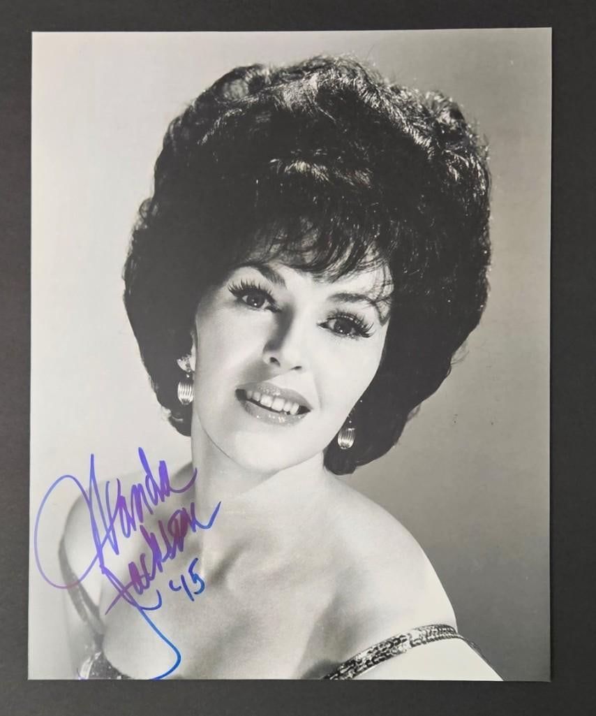 Wanda Jackson Signed 10" x 8" Photo (Third Party Guaranteed): Black-and-white 10" x 8" photo signed in blue felt tip marker by musician Wanda Jackson. In fine condition.ProvenanceEaton & Brennan Auctions guarantees this lot to pass Third-Party Authentication.