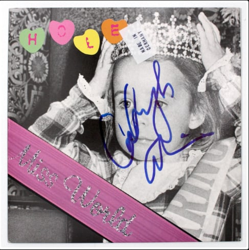 Hole: Courtney Love Cobain Vintage Married-Name Signed “Miss World” 45 Record (Beckett): “Miss World” 45 signed on the cover in blue felt tip marker by Hole singer Courtney Love with her married name “Courtney Cobain.” Measuring approximately 7” x 7”