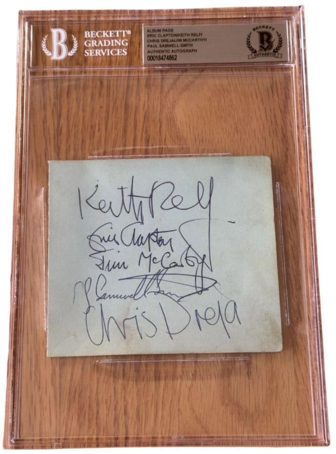 The Yardbirds Group Signed Slabbed 4" x 4.5" Cut (5 Sigs) (Beckett/BAS Authentication): Gray slabbed 4" x 4.5" cut signed in blue ballpoint pen by The Yardbirds band members James McCarty, Chris Dreja, Keith Relf, Eric Clapton, and Paul Samwell Smith. Written on the back is the inscripti