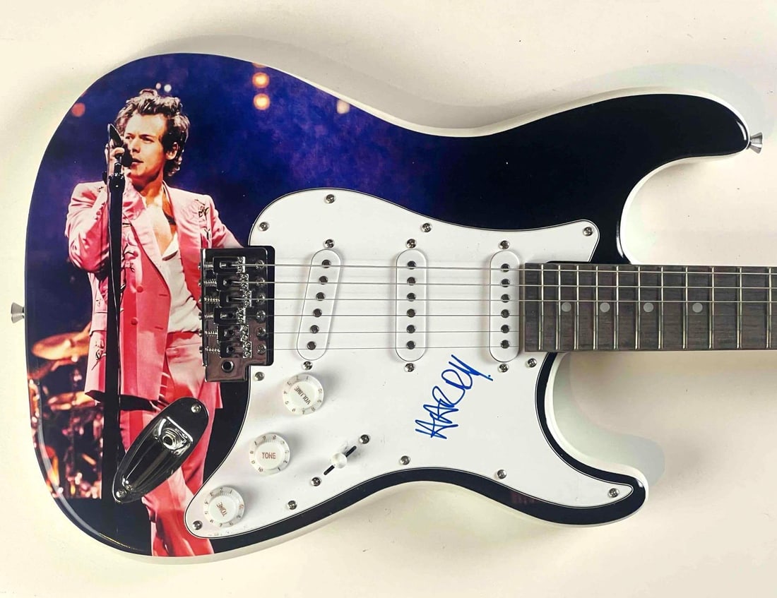 Harry Styles In-Person Signed Custom Fender-Style Guitar w/ Live Stage Image Artwork (JSA): Custom electric Fender-style guitar featuring a vivid full-color image of Harry Styles performing live in his signature pink suit, boldly signed on the white pickguard in blue felt tip marker with his