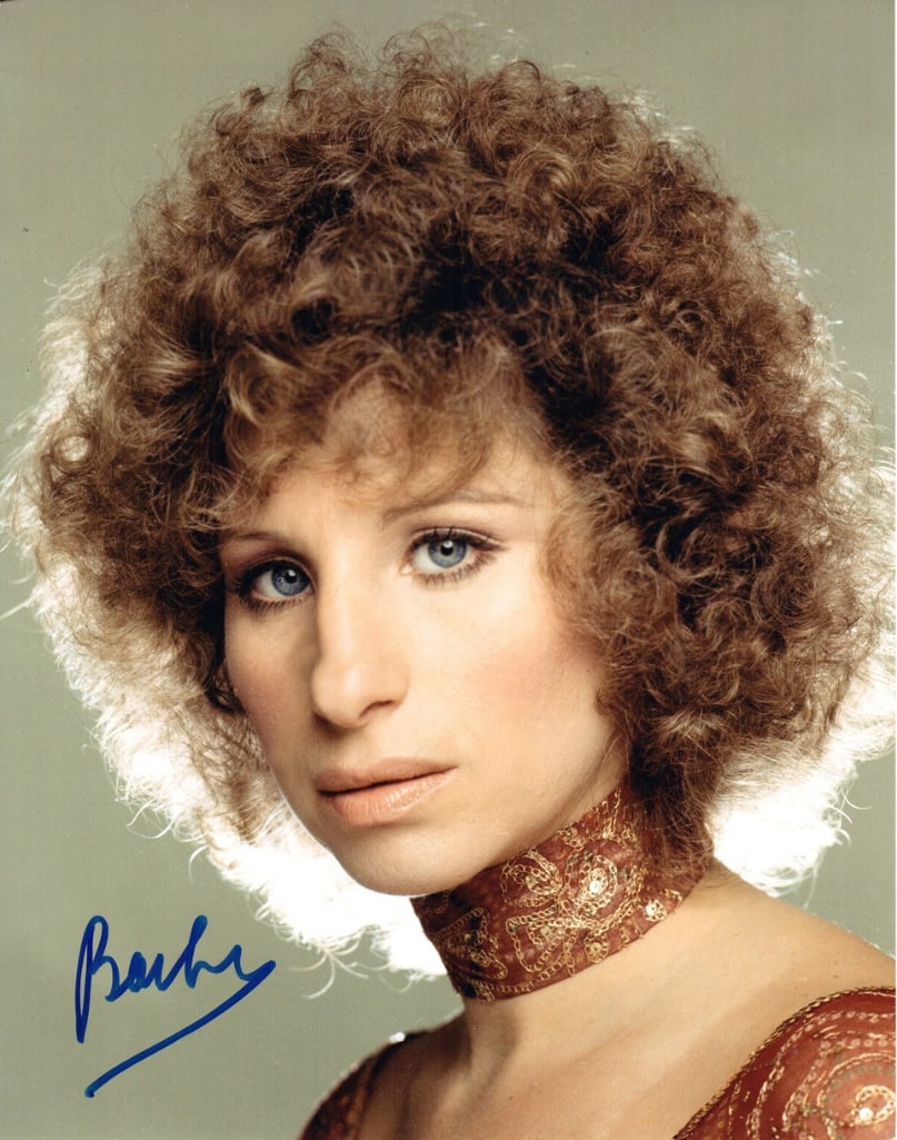 Barbra Streisand Signed 14" x 11" Photo (JSA Authentication): Color 14" x 11" photo signed in blue felt tip marker by musician Barbra Streisand. In fine condition. Accompanied by a full Letter of Authenticity from JSA (#Z42971). Obtained in-person.